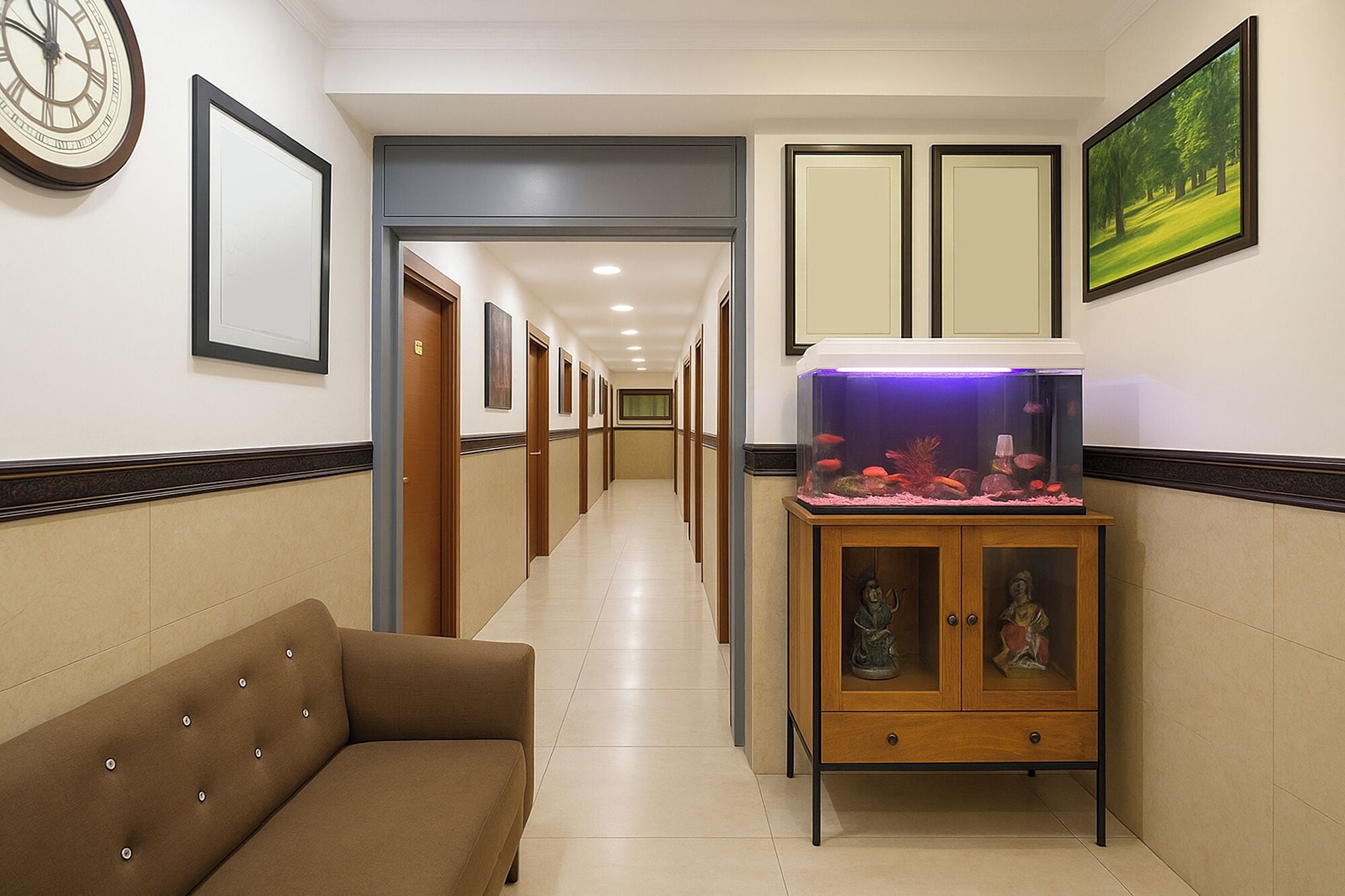 Un pasillo de hotel con un sofá, un acuario, cuadros enmarcados y puertas.