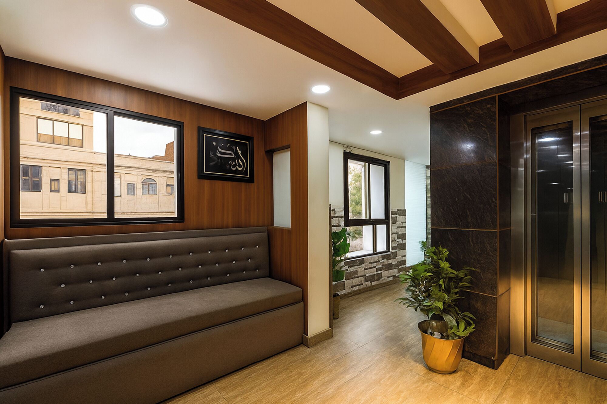 A modern interior with a bench, a potted plant, and an elevator.