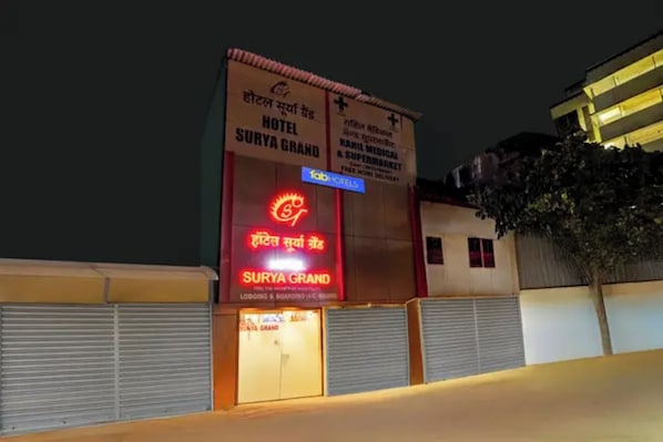 A hotel named 'Surya Grand' with a prominent sign and a closed shuttered entrance. - Via Surya Grand (Mumbai)