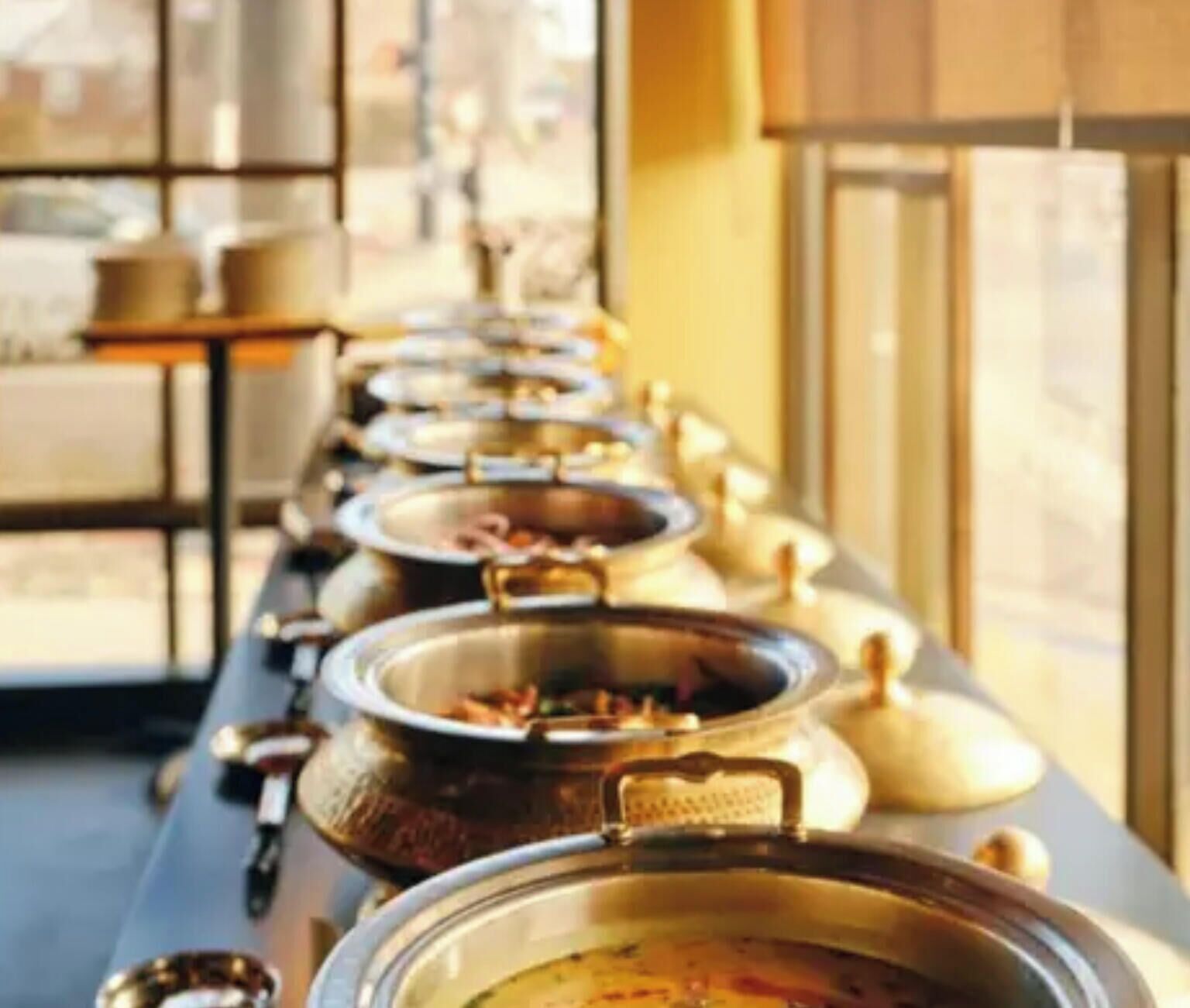 A buffet line with various dishes in metal containers.