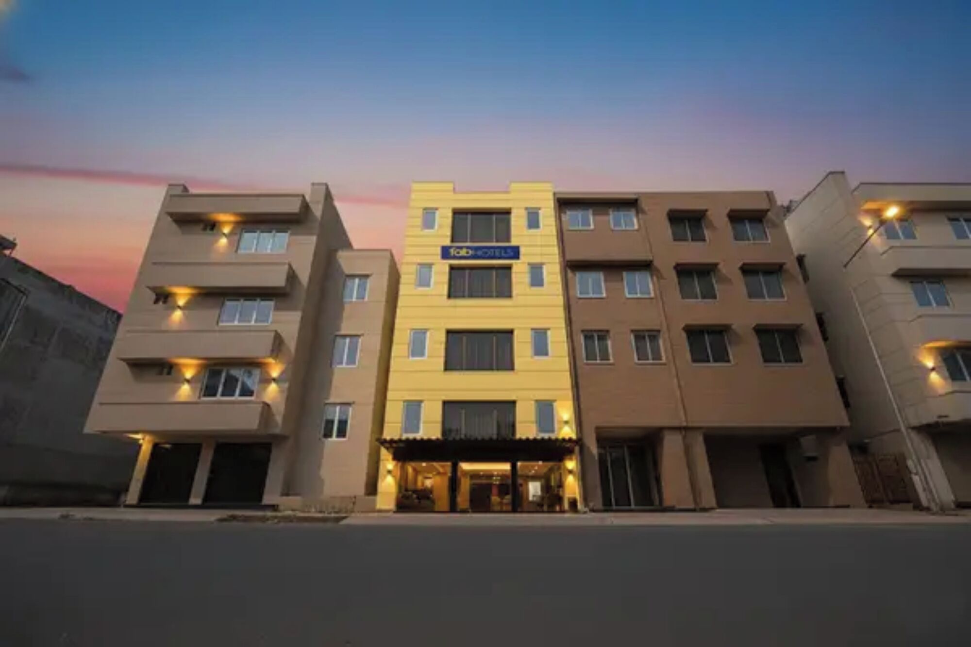 A multi-story hotel with a central entrance, balconies, and a flat facade.