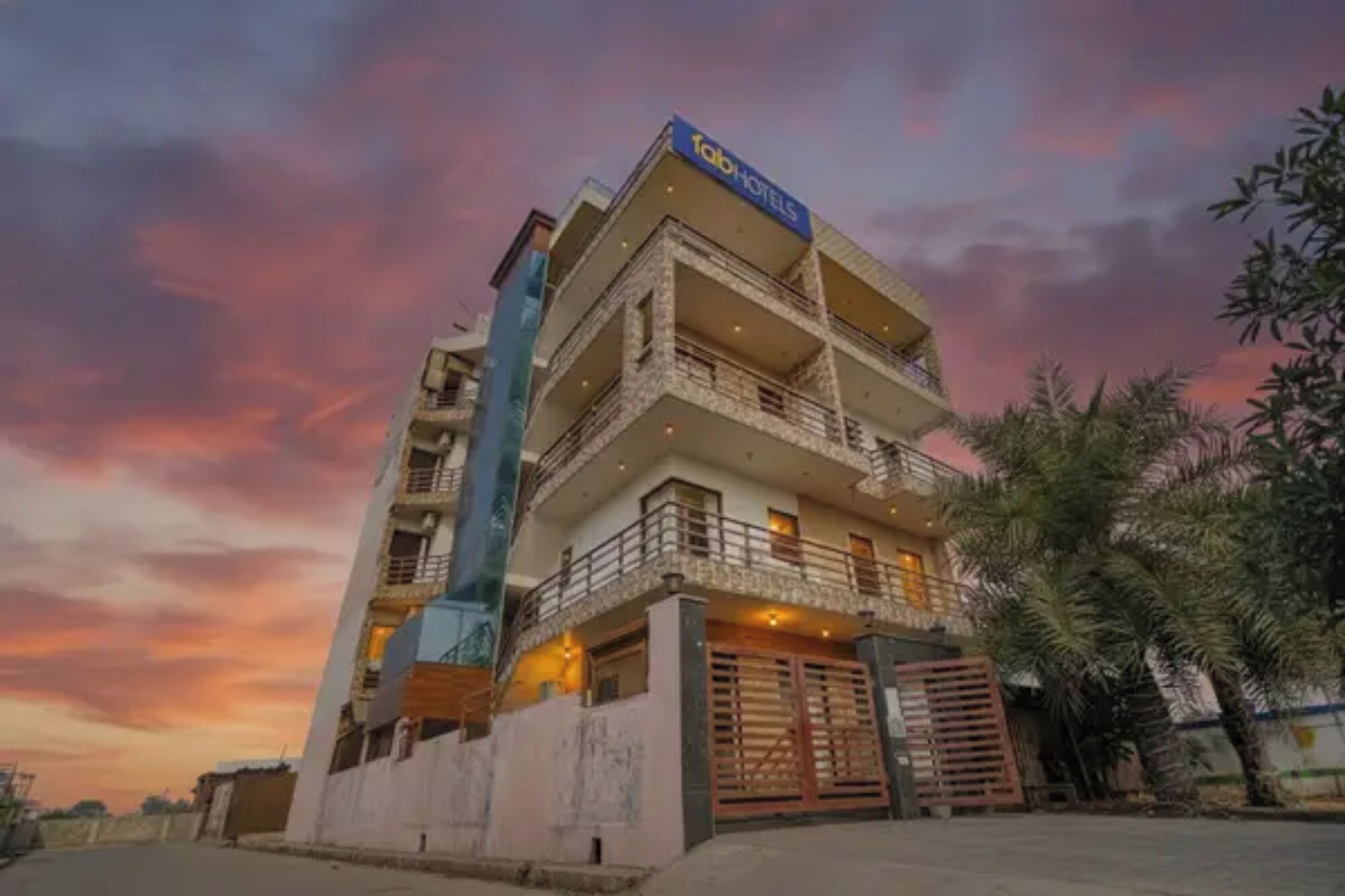 Un hôtel à plusieurs étages, doté d’une enseigne bien visible, de balcons et d’une entrée fermée par un portail.