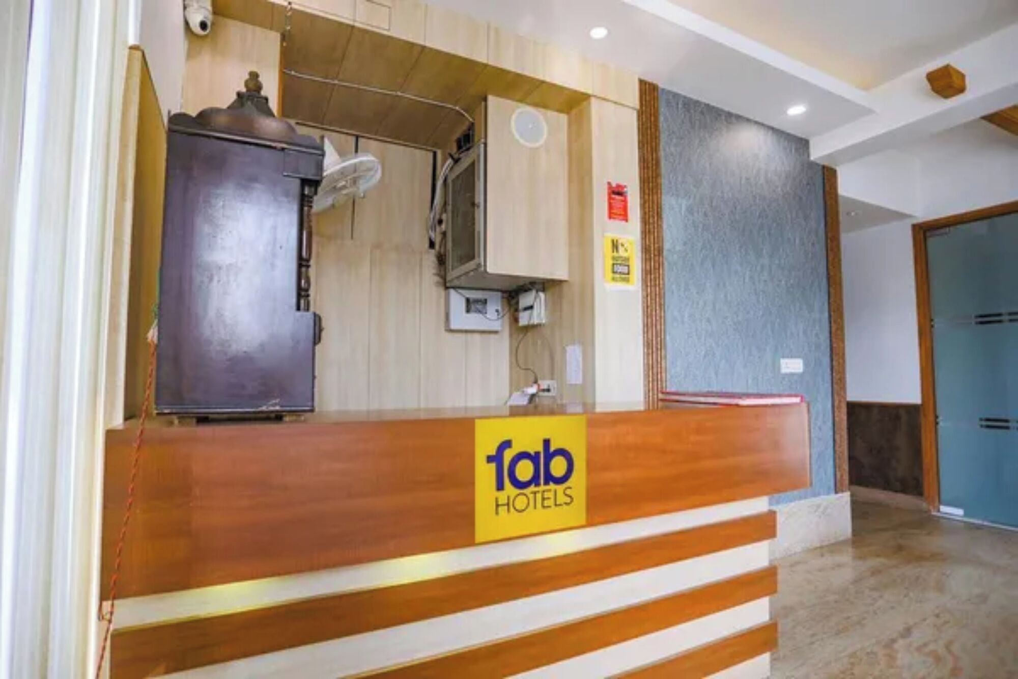 Een receptiebalie met een houten afwerking en een bord waarop 'Tab Hotels' staat.