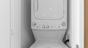 A front view of a white washing machine with control knobs and buttons for various settings. - Modern Apt Resort Style Oasis Ocean Air Miami (Hollywood)