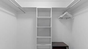 Ein weißer Kleiderschrank mit eingebauter Leiter und Kleiderstange.