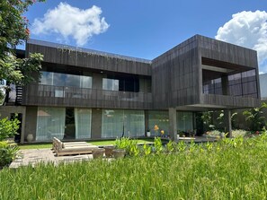 Ein modernes, zweistöckiges Gebäude mit Flachdach und Balkon.