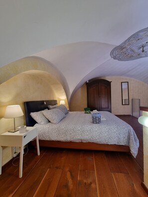 A bedroom with a bed, bedside table, lamp, and a ceiling with a decorative design. - Historic Loft, just a short walk from the train station and the historic district (Catania)