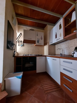 A compact kitchen with white cabinets, a tiled backsplash, and a wooden ceiling. - Historic Loft, just a short walk from the train station and the historic district (Catania)