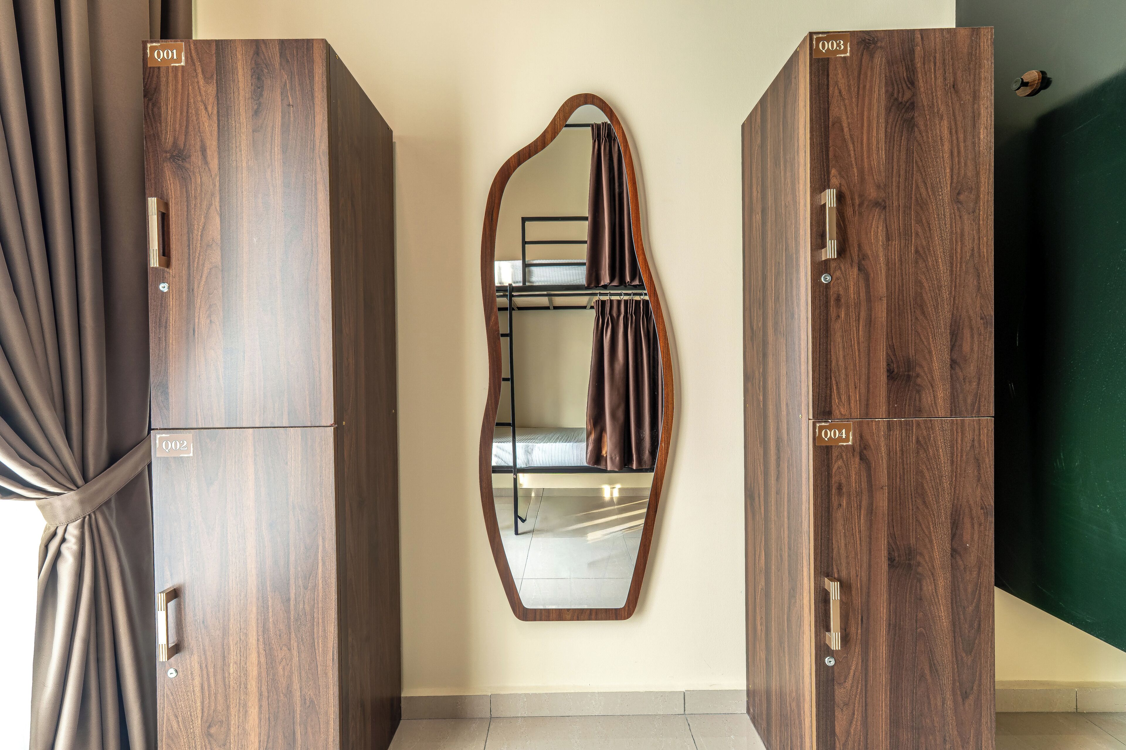 Una habitación con dos armarios de madera, un espejo y una cortina.
