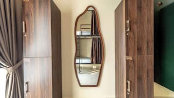 Una habitación con dos armarios de madera, un espejo y una cortina.
