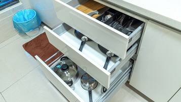 A kitchen drawer with utensils and cookware.