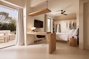 Ein modernes Schlafzimmer mit Bett, Nachttisch und Schreibtisch mit Lampe.