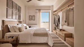 Ein Schlafzimmer mit Bett, Nachttisch und Blick ins Freie.