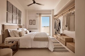 Ein Schlafzimmer mit Bett, Nachttisch und Blick ins Freie.