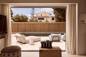 A balcony with a sofa set, a small table, and a potted plant. - East Coast Villa – Dream Living (Rafina)