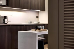 Een moderne keuken met een wit aanrecht, donkerhouten kastjes en een ingebouwde magnetron.