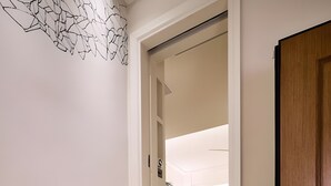 En trappe fører op til et værelse med en seng, et natbord og en lampe.