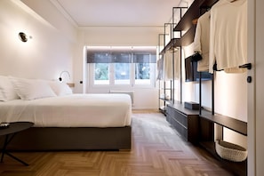 A modern bedroom with a bed, bedside table, and a built-in wardrobe with hanging space. - Estia Athens – Your Luxurious Urban Retreat (Athens)