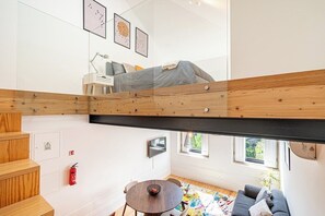A modern interior with a loft bed, a dining area, and a sofa. - Modern Apt in Historic Porto's Largo da Lapa (Porto)