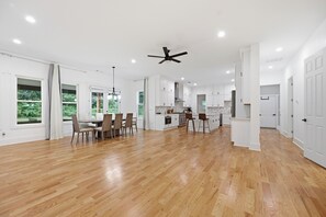 A spacious kitchen with white cabinets, a dining area with a table and chairs, and a ceiling fan. - New Luxury Family-Friendly Getaway 4BR Home Near Atlanta/Sleeps 14+ (Lawrenceville)
