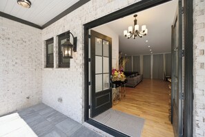 Ein modernes Interieur mit Ziegelwand, schwarzer Tür und Holzboden.