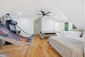 A bedroom with a bed, a ceiling fan, a hammock, and a ceiling-mounted exercise machine. - New Luxury Family-Friendly Getaway 4BR Home Near Atlanta/Sleeps 14+ (Lawrenceville)