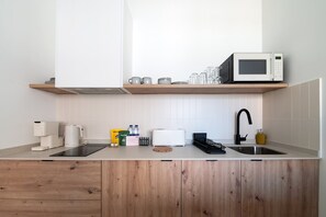 A modern kitchen with a microwave, toaster, and sink. - GuestReady - Estudio super acogedor en Madrid (Madrid)