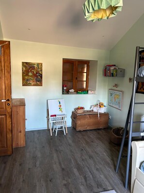 Ein Zimmer mit einem Holzschrank, einer Whiteboardtafel, einem Fenster mit Blick und einem Bücherregal.