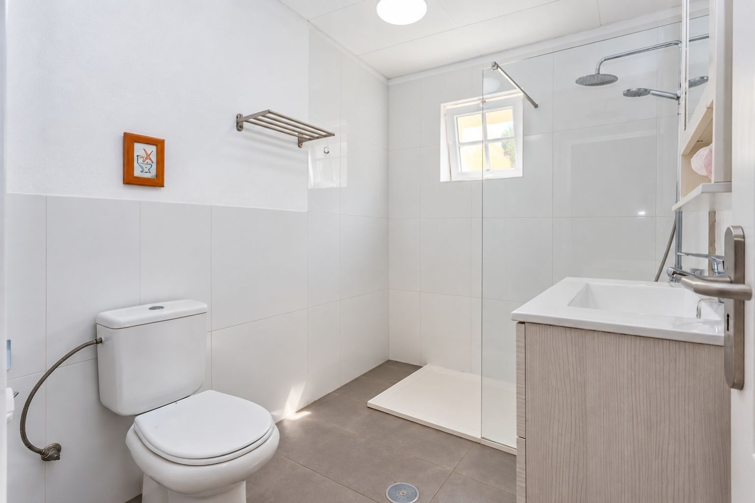 Ein modernes Badezimmer mit Toilette, Dusche und Waschbecken.