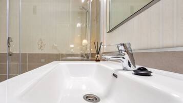 Un baño moderno con un lavamanos blanco, grifo cromado y un espejo encima.