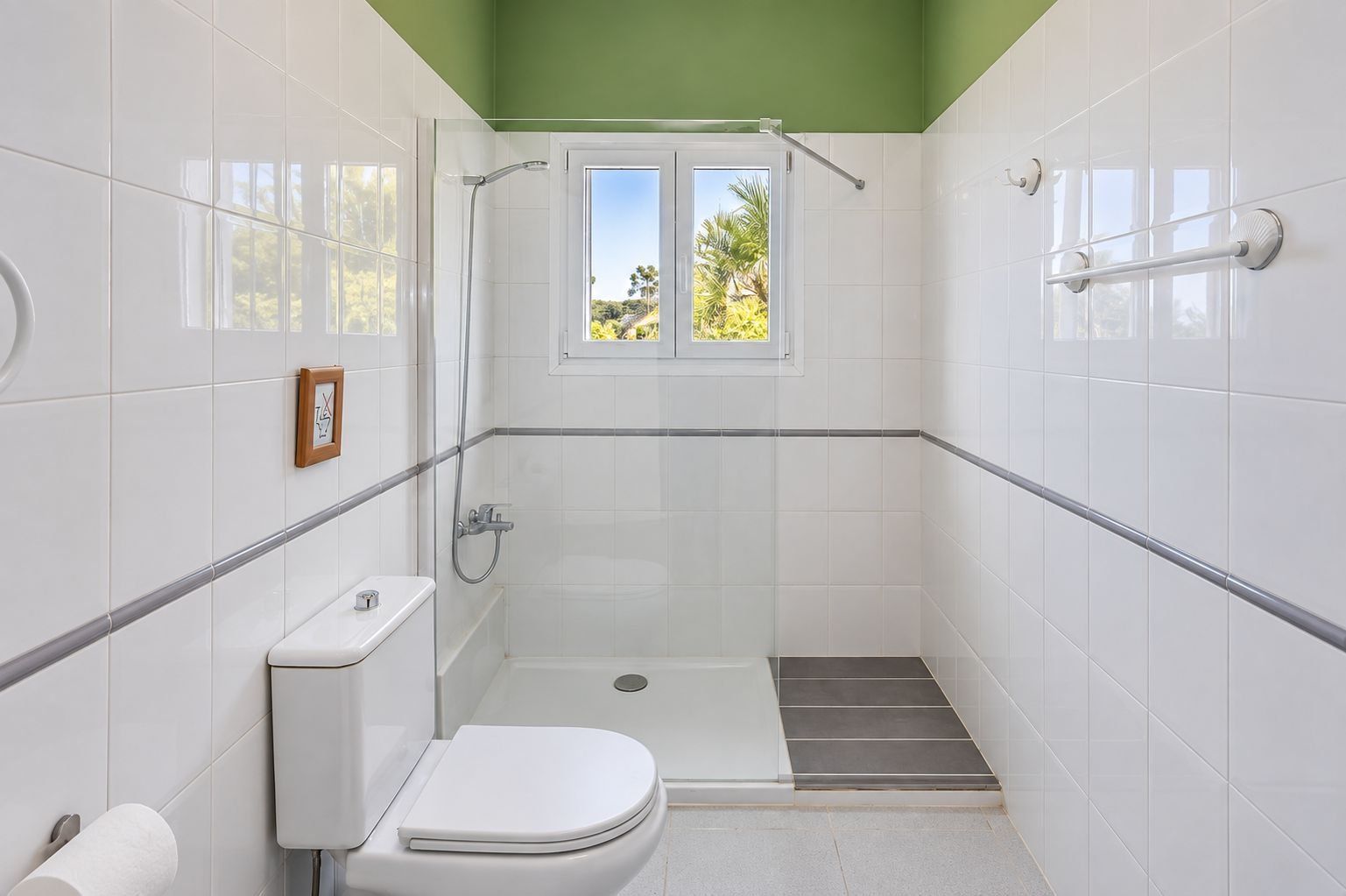 Un baño pequeño y cerrado con inodoro, ducha y ventana.
