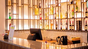 Zona de bar con diversas botellas de licor y copas a la vista.