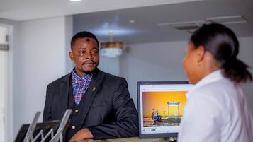 Un hombre con traje sentado en un escritorio frente a un monitor de computadora que muestra un video de YouTube.
