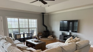 Ein Wohnzimmer mit einem großen Sofa, einem Couchtisch, einem Kamin und einem Fernseher.