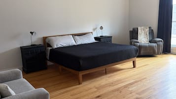 Une chambre à coucher avec un lit, une chaise, un bureau et un ventilateur de plafond.