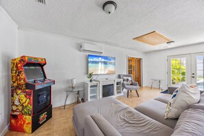 Ein modernes Wohnzimmer mit Spielkonsole, Flachbildfernseher und Kamin.