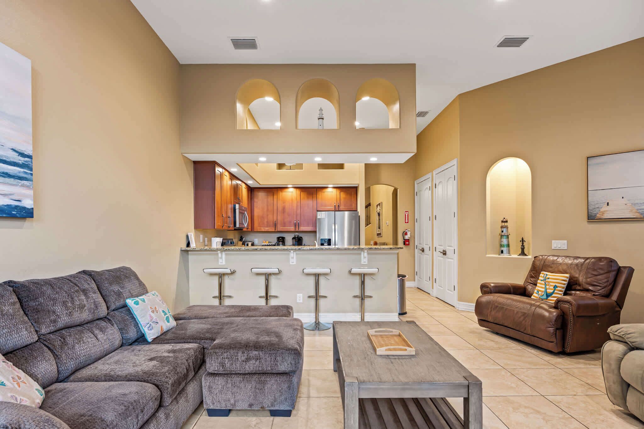 A modern living room with a grey sofa, a brown leather chair, and a wooden coffee table.