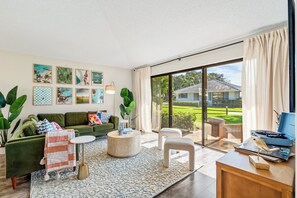 Living room with view of the patio. - Modern 2BR 2BA PGA Home in Paradise, 2 Min to Pool, 15 Min to Beach (Palm Beach Gardens)