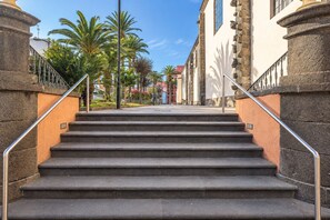 A set of stone steps leading up to a building with a metal handrail on both sides. - GuestReady - Urban Suite City Center (La Laguna)