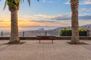Eine Parkbank mit Blick auf eine Stadt und ein Berg in der Ferne.