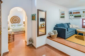 Ein Hotelzimmer mit einem Bett, einer Couch, einem Spiegel und einem kleinen Tisch mit einem Korb.