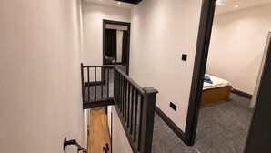 Ein Flur mit einer Treppe zu einem Schlafzimmer.