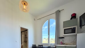 A modern kitchen with a dining area, large windows, and a view of the outdoors. - Studio Apartment 'Diamant' with Balcony and Wi-Fi (Nice)