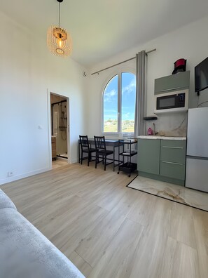 Eine moderne Küche mit Essbereich, großen Fenstern und Blick ins Freie.