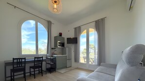 A modern kitchen with a dining area, a sofa, and large windows. - Studio Apartment 'Diamant' with Balcony and Wi-Fi (Nice)