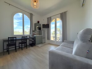 Eine moderne Küche mit Essbereich, einer Couch und großen Fenstern.