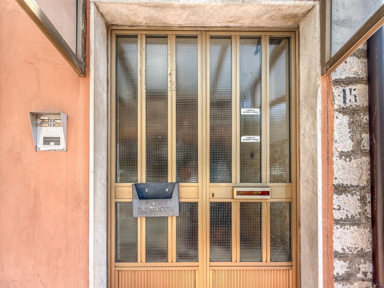 Une porte dotée d’une fente pour le courrier et d’une pancarte indiquant qu’il s’agit d’un espace public.