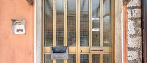 Uma porta com uma abertura para correspondência e uma placa indicando área pública.