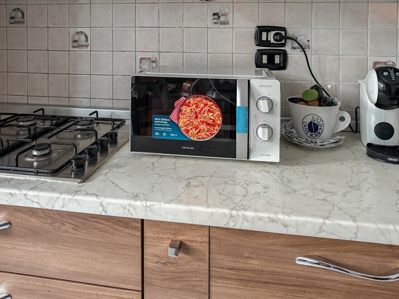 Une cuisine équipée d’un four à micro-ondes, d’une cuisinière à gaz et d’une machine à café.