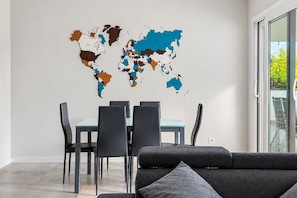 A modern dining area with a world map mural, a dining table, and chairs. - GuestReady - Marbella with terrace and pool (Marbella)
